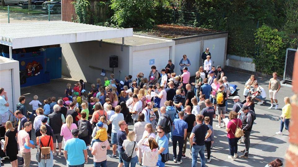 Carport und Garagen, Personen auf Bänken, Puppenbühne im Carport