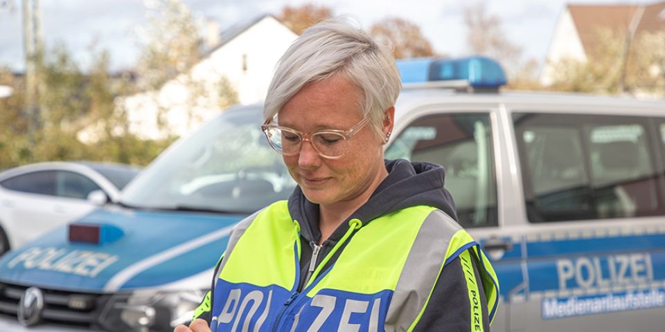 Foto Nadine Richter vor Streifenwagen der Polizei